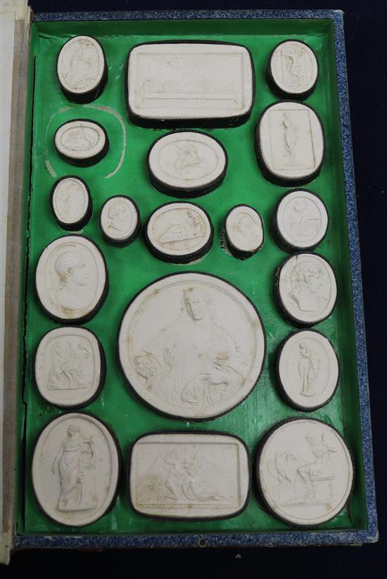 A collection of 19th century Italian plaster cameos in a faux book box.